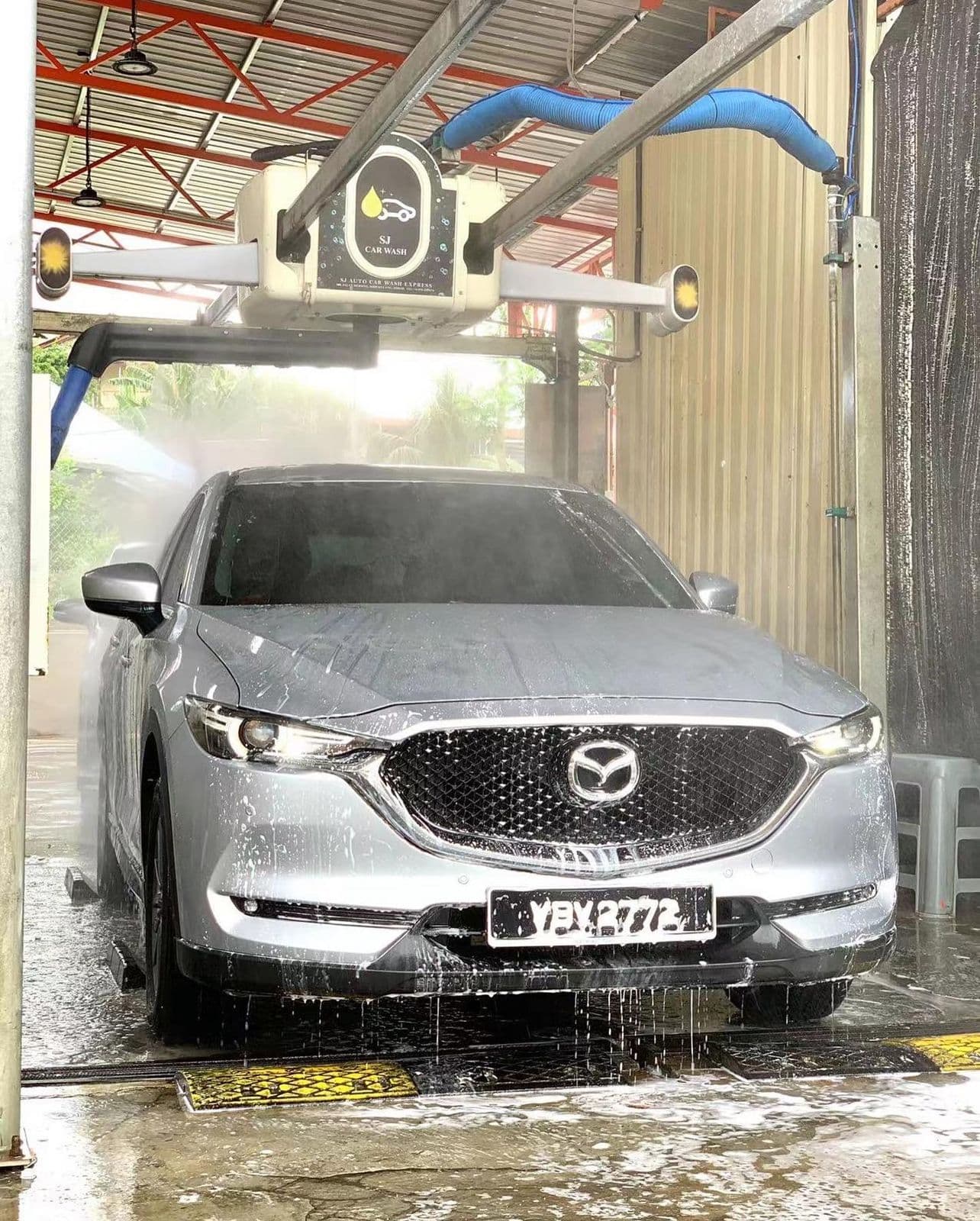 An SUV being washed by the automatic wash arm at SJ Auto Car Wash