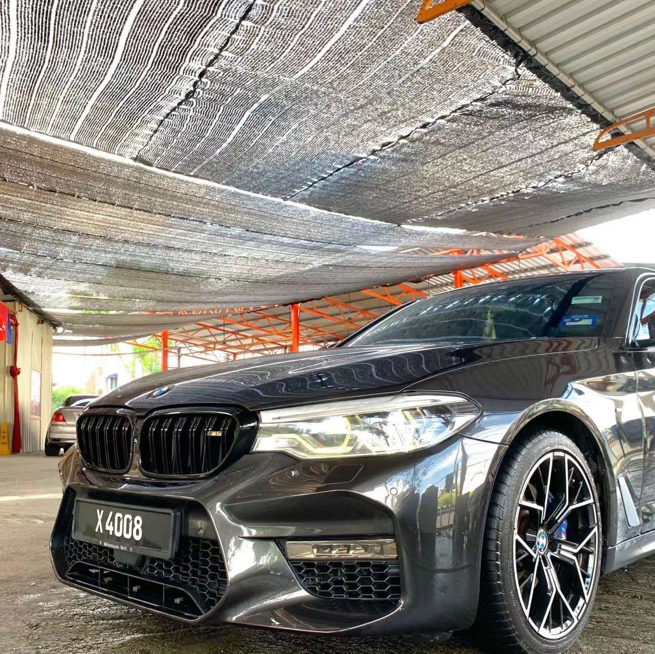 A dark sedan in a wash bay at SJ Auto Car Wash