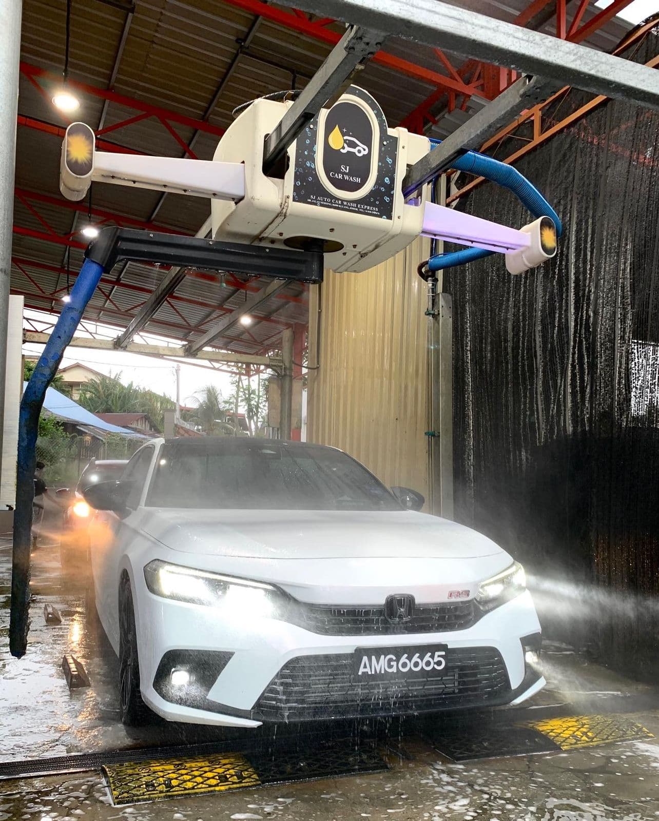A car under the automatic wash arm at SJ Auto Car Wash